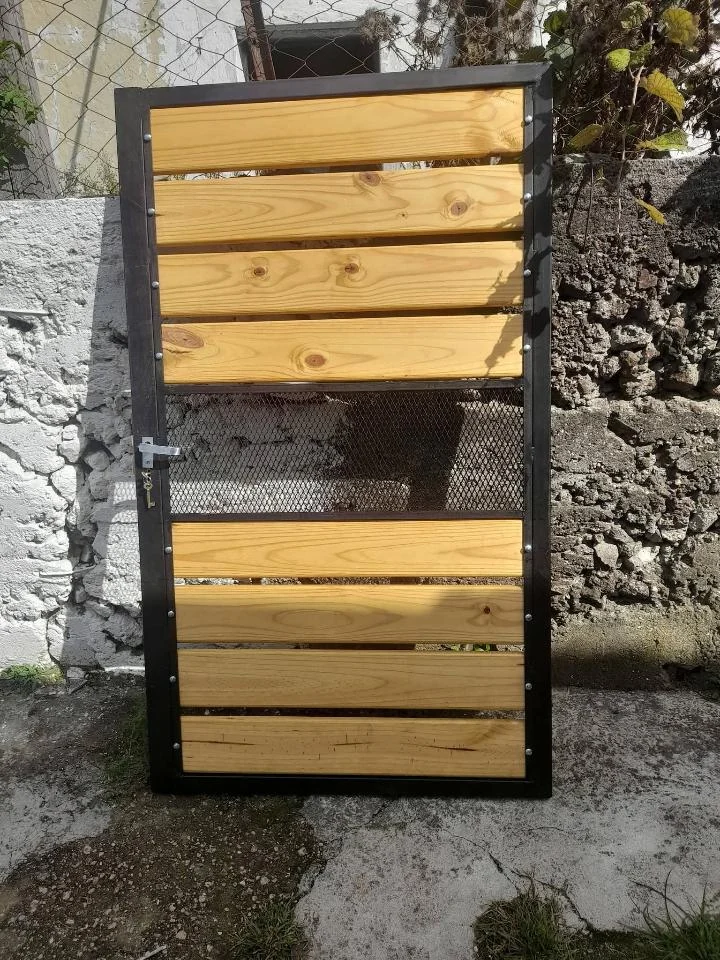 Puerta de acceso de hierro con madera, trabajo de Nicolás Grand